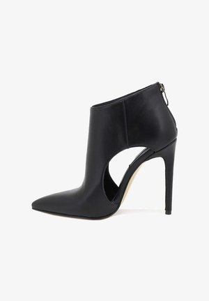 Stivali alla caviglia in pelle nera con punte affusolate, design con tagli laterali, chiusura con zip sul retro e alto tacco a stiletto.