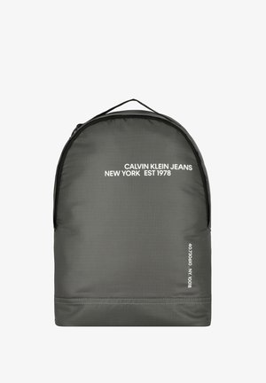 Grijze rugzak van duurzame stof met een gestructureerde afwerking. Heeft witte logo-teksten en numerieke details in de rechterbenedenhoek.