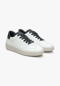 Witte leren sneakers met zwarte accenten, voorzien van platte veters, een gladde textuur en een gevoerde zool. Minimalistisch ontwerp met geperforeerde details.