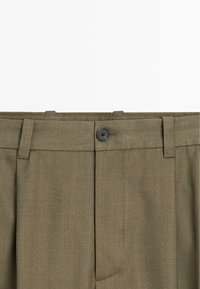 Olive green trousers made of textured fabric, featuring a straight cut, single button closure, and belt loops at the waist.
