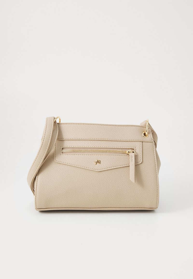 Beige tekstureret håndtaske med guldfarvet hardware, udstyret med en frontlomme med lynlås og en justerbar rem. Kompakt rektangulær design.
