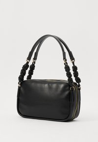 Black leather handbag with a rectangular shape, featuring knotted handles and gold hardware accents, closed with a zipper.