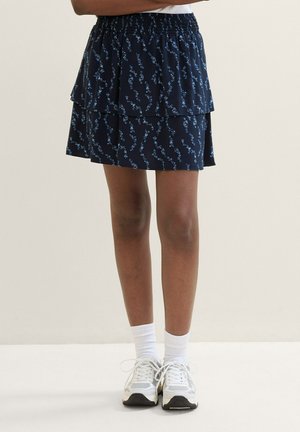 Marineblauwe gelaagde rok met elastische tailleband, voorzien van een bloemenpatroon in lichtblauw, gemaakt van lichtgewicht stof.