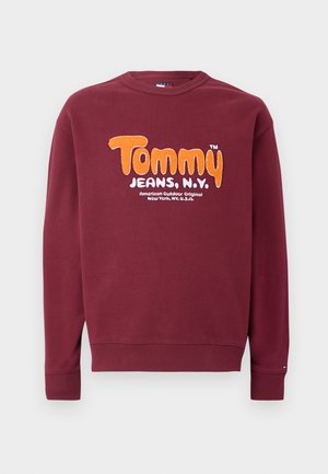 Sweatshirt bordeaux com texto laranja e branco "Tommy Jeans, N.Y." e texto adicional pequeno em branco abaixo na parte da frente.
