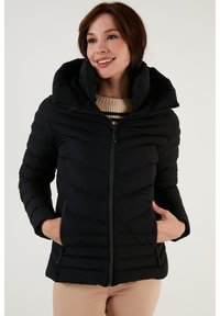 Black puffer jacket with a padded design, high collar, and hood. Features zip closure and side pockets. Smooth texture, lightweight material.
