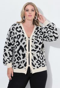 Cárdigan de leopardo negro y crema con escote en V profundo, cierre con cordón y puños y dobladillo acanalados. Material de punto suave.