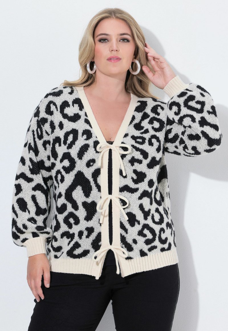 Cárdigan de leopardo negro y crema con escote en V profundo, cierre con cordón y puños y dobladillo acanalados. Material de punto suave.