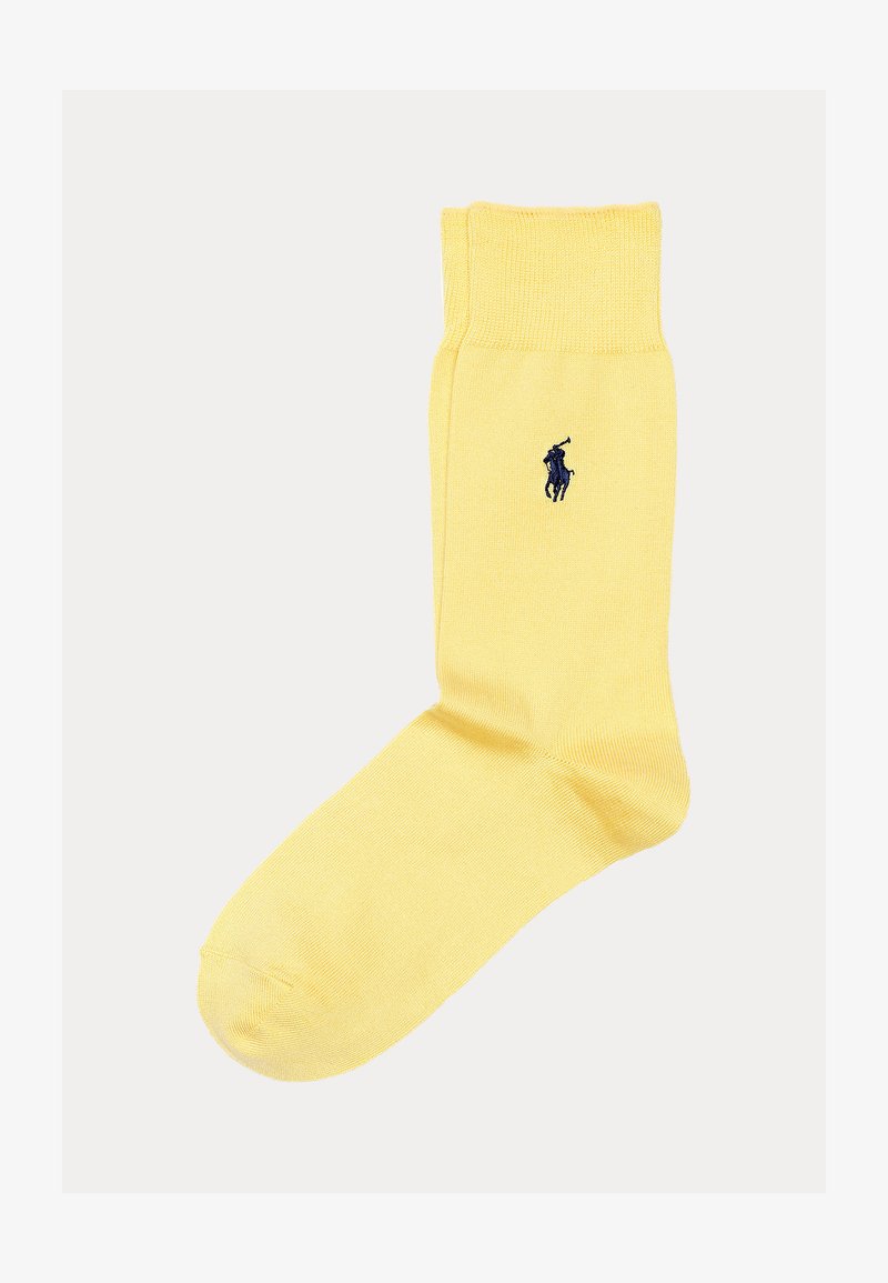 Μονή κίτρινη κάλτσα με ριμπ μανσέτα και κεντητό λογότυπο ποδοσφαιριστή πόλο σε ναυτικό μπλε στο αστράγαλο, πάνω σε λευκό φόντο.