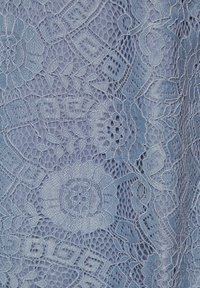 Tiul w jasnoniebieskim kolorze, z kwiatowymi wzorami i misternymi detalami, prezentujący teksturowany, półprzezroczysty wzór.