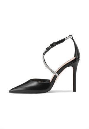 Scarpa décolleté nera in pelle con punta appuntita, cinturino alla caviglia decorato con dettagli argentati e design elegante con tacco a stiletto.