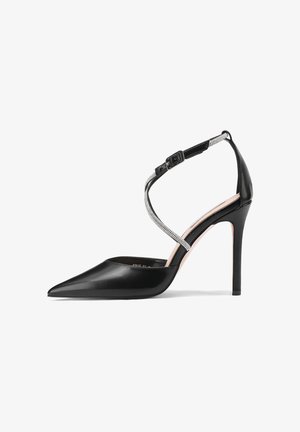 Scarpa décolleté nera in pelle con punta appuntita, cinturino alla caviglia decorato con dettagli argentati e design elegante con tacco a stiletto.