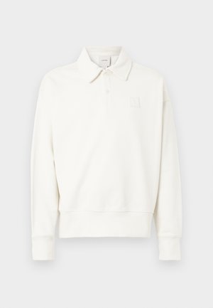 White pullover polo shirt with a collar, featuring a subtle embroidered logo on the left chest, made of soft fabric with a slightly textured finish.