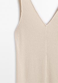 Haut sans manches beige en maille avec un col en V et une texture côtelée.