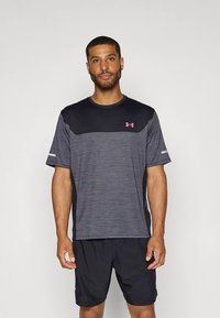 Svart og grå trenings-T-skjorte med korte ermer, med en melert tekstur og en helsvart øvre del. Inkluderer rosa logodetalj.