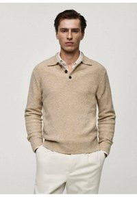 Maglione a maglia beige con colletto, tre bottoni sul collo, polsini e orlo a costine, e una texture morbida. Abbina a pantaloni di colore chiaro.