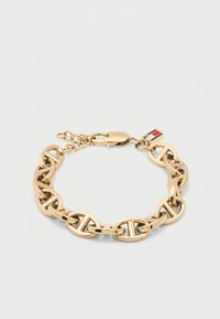 Βραχιόλι αλυσίδας από χρυσό με οβάλ κρίκους που διαθέτει οριζόντιο σχεδιασμό μπάρας και μικρό ορθογώνιο γούρι με ριγέ κόκκινο, άσπρο και μπλε.