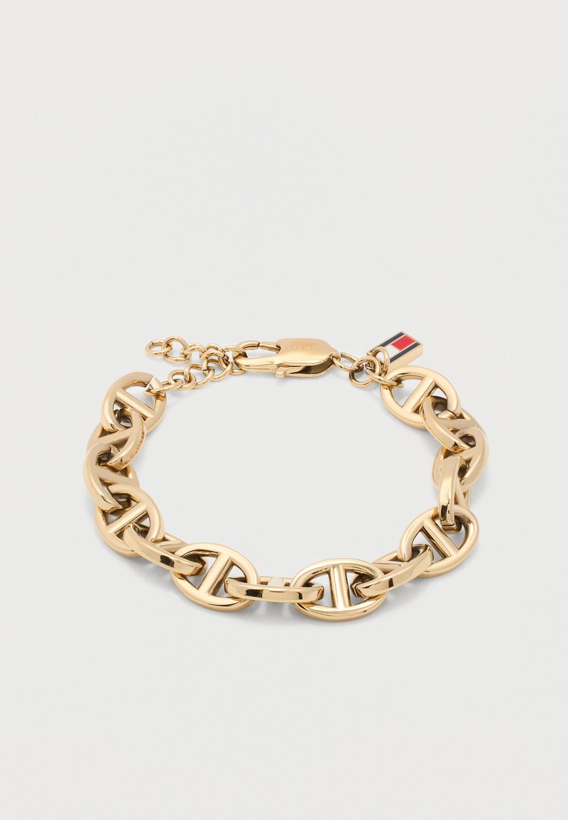 Βραχιόλι αλυσίδας από χρυσό με οβάλ κρίκους που διαθέτει οριζόντιο σχεδιασμό μπάρας και μικρό ορθογώνιο γούρι με ριγέ κόκκινο, άσπρο και μπλε.