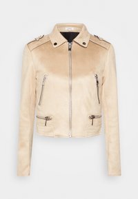 Veste de biker en faux suède beige avec une fermeture éclair à l'avant, deux poches zippées et des épaulettes. Texture lisse et design ajusté.