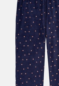 Navy blue velvet pajama pants featuring scattered copper star patterns, with an elastic waistband for comfort and a soft texture.