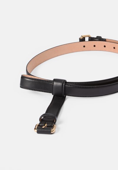 Cinturón de cuero negro con un acabado suave, hebilla en tono dorado y agujeros ajustables. Forrado con material en tono claro para contraste.