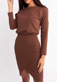 Brą dress z długim rękawem w kolorze brązowym, wykonana z miękkiego materiału, z dopasowaną talią i asymetrycznym dołem, z marszczeniem na linii talii.