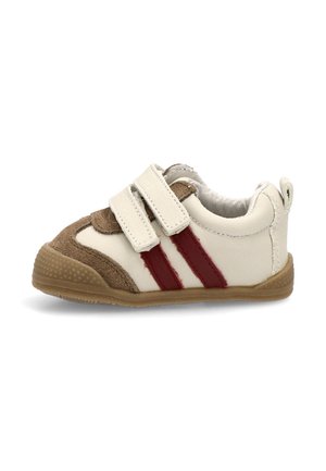 Zapatilla blanca y marrón con dos rayas rojas, hecha de cuero y ante, que cuenta con una correa de velcro y una suela de goma texturizada.