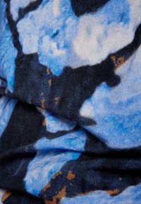 Blau gemusterter Stoff mit weicher Textur, der abstrakte Formen in hellblau und dunkelblau zeigt, mit Akzenten in Braun.