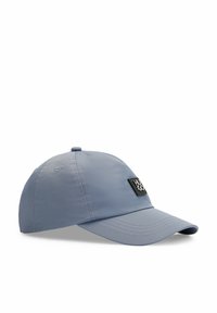 Gorra de color azul claro hecha de nailon con visera curva, que presenta una etiqueta negra con texto blanco. Se pueden ver costuras decorativas a lo largo de los bordes.