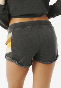 Shorts de algodón grises con dobladillos enrollados, que presentan paneles laterales multicolores en tonos pastel. Textura suave y cinturilla elástica.