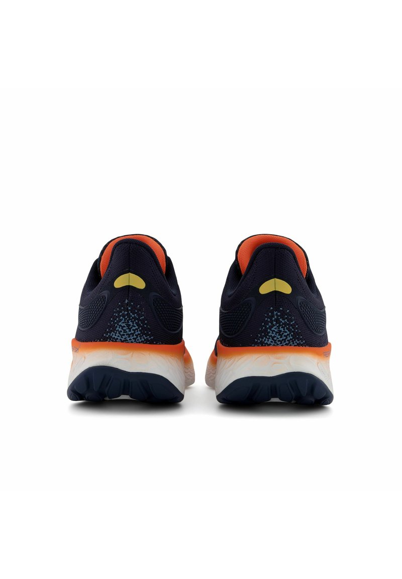 Las zapatillas de correr tienen una parte superior de malla azul marino con acentos en naranja, una suela acolchada y una suela gris texturizada para mayor agarre.