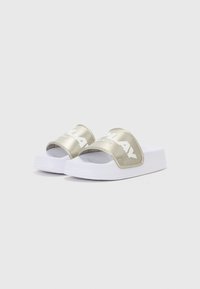 Slide sandalen met een glanzende gouden band met witte tekst op een witte schuimen zool, gladde textuur en open teen ontwerp.