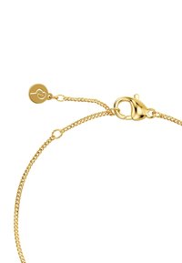 Gold bracelet featuring a delicate chain, a lobster clasp, and a tag with a heart logo. Smooth texture, lightweight design.