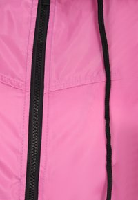 Giacca rosa leggera con una texture liscia, dotata di una cerniera nera centrale e di un cordino nero sul colletto. Tessuto sintetico.