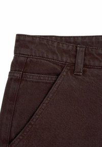 Bruine denimstof met een close-up van de tailleband, inclusief een riemlus en topgestikte pocketdetails. Gladde textuur met een lichte glans.