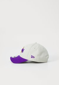 Gray cap with a purple visor, featuring a sports logo in yellow, purple, and white. Includes a small purple brand tag on the side.
