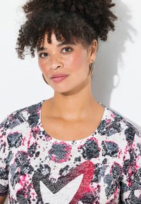 Kortærmet T-shirt med rund hals i hvid, med et struktureret rosa og sort dyreprint og et stort, udsmykket hjerte-design.