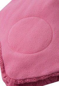 Coperta in pile rosa con un motivo circolare in rilievo al centro. I bordi presentano una texture lavorata a maglia, che aumenta il comfort e il calore.