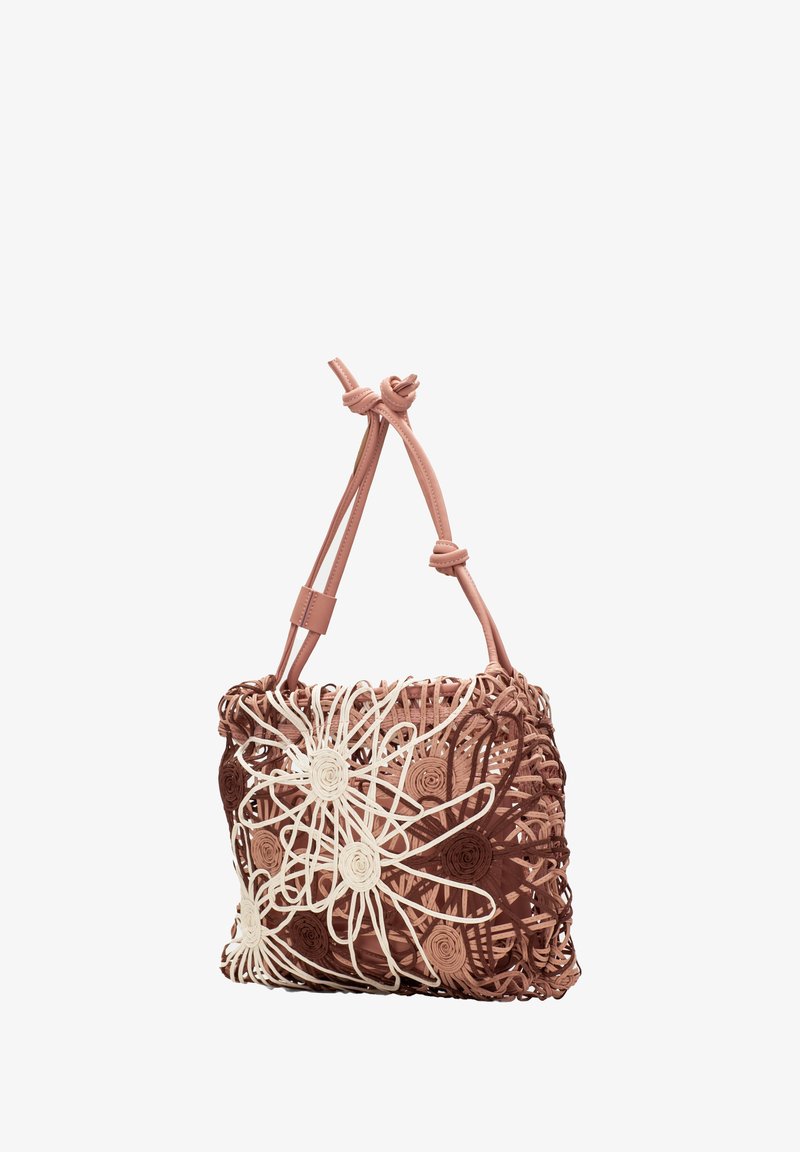 Sac à main tissé rose avec des motifs floraux en blanc et marron, doté de bretelles en cuir nouées et d'un design ouvert et aérien.