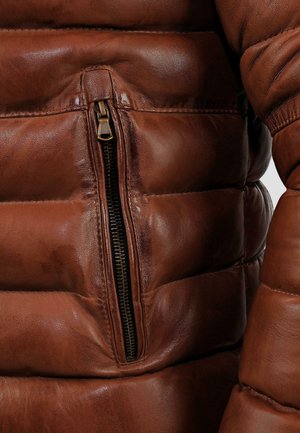 Brown leather puffer jacket featuring a zippered pocket and quilted texture, showcasing a smooth finish and slight sheen.