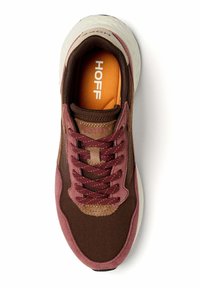 Hnědý textilní teniska s fialovými a béžovými akcenty. Má šněrovací design, polstrovaný límec a oranžovou vložku se vstříknutým logem.