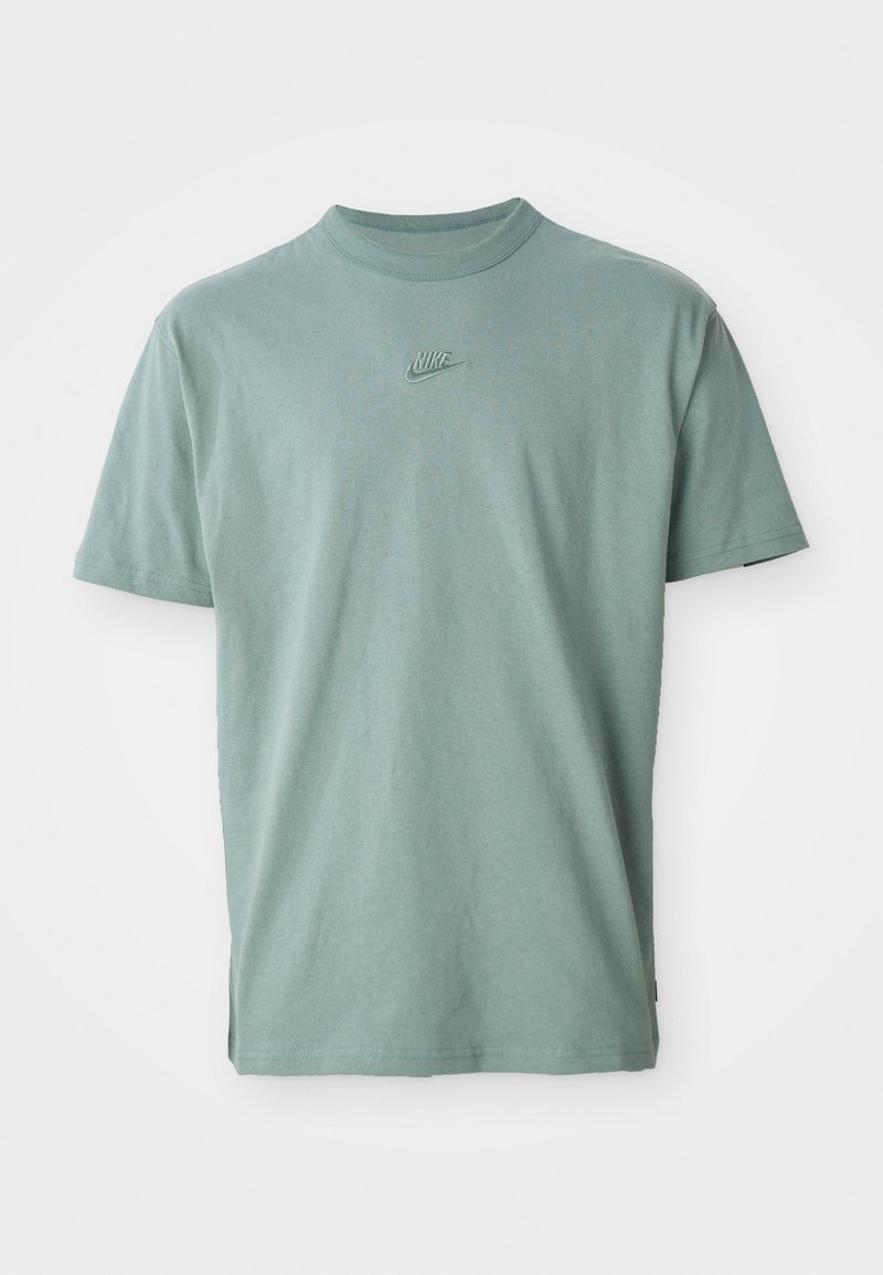 T-shirt de algodão verde com mangas curtas, decote redondo canelado e logótipo da Nike bordado no peito. Textura suave e ajuste descontraído.