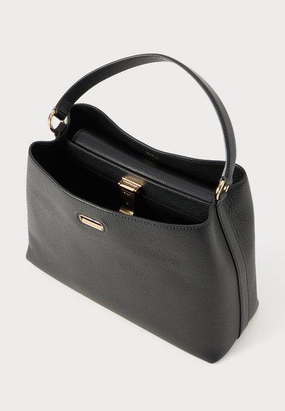 Sac à main en cuir noir avec un design structuré, doté d'un fermoir doré, d'une seule poignée et d'une surface texturée. L'intérieur comprend une poche.
