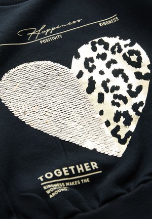 Felpa nera con un grande cuore bianco fatto di paillettes e un cuore con stampa leopardata. Testo dorato con le parole "Felicità, Positività, Gentilezza, Insieme."