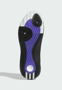 Suola di scarpa con battistrada in gomma nera, bianca e viola, pad di grip testurizzati circolari e una schiuma bianca visibile attraverso un ritaglio circolare.