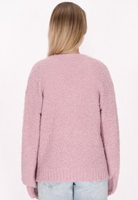 Rosa fluffig stickad tröja med avslappnad passform, långa ärmar och ribbat nederkant. Enkel design på baksidan utan dekorationer.