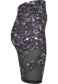 Zwarte legging met een witte hemelse print van sterren, manen en planeten. Heeft netvormige uitsparingen aan de zijkanten voor ventilatie.
