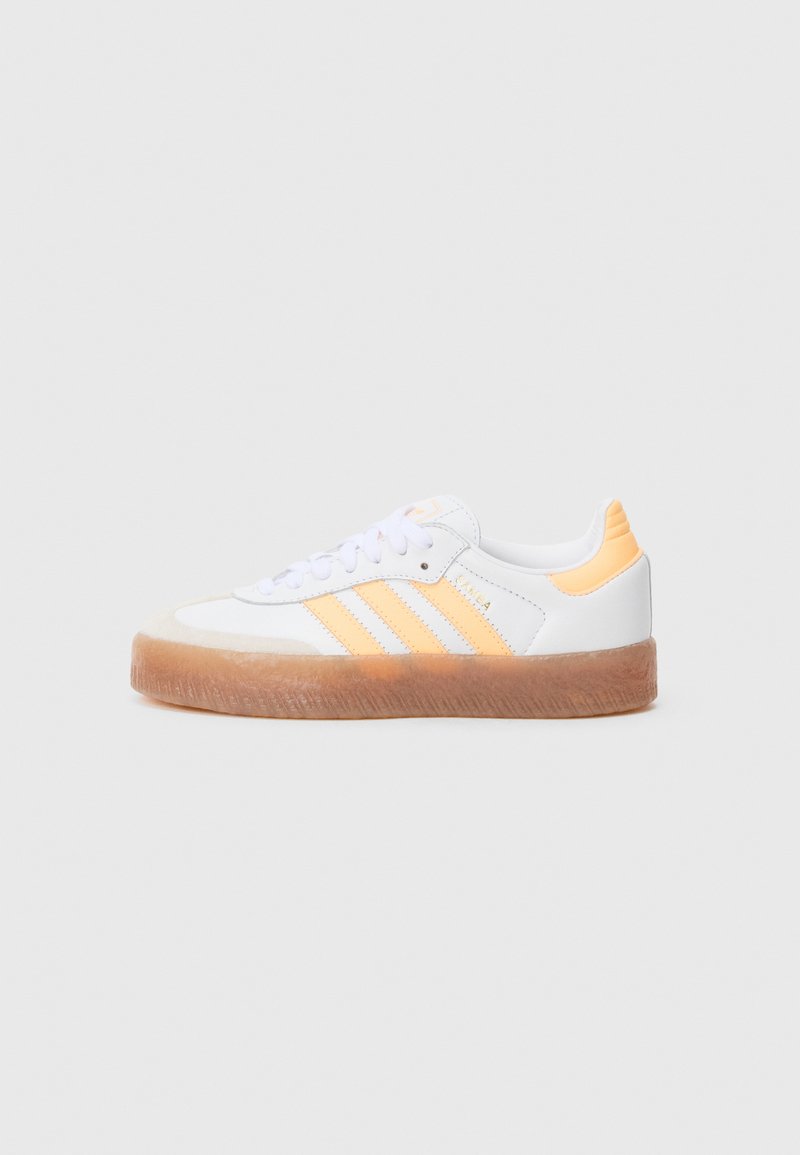 Biele tenisky s oranžovými detailmi, s tromi pruhmi na boku, textúrovanou gumovou podrážkou a šnurovaním.