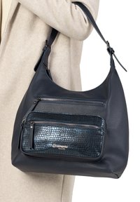 Sac à main en cuir marine avec une finition texturée, doté de deux poches zippées. Le sac est muni d'une bandoulière et d'un accent de logo.