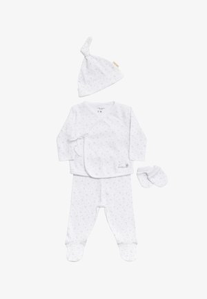 El conjunto de ropa para bebé blanco incluye una camiseta envolvente con lazo, pantalones con pies, un gorro con nudo y manoplas. La tela tiene un sutil estampado de lunas crecientes.