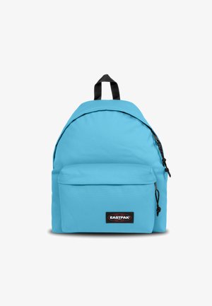 Mochila de color azul claro, hecha de tela, con forma curva, un bolsillo frontal con cremallera y tirantes y marcas de acento en negro.